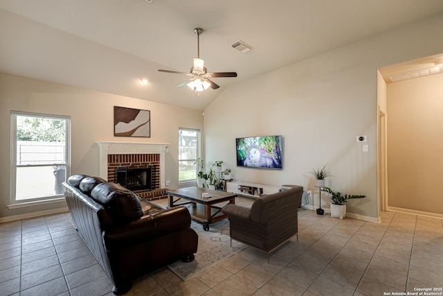 living room with lofted ceiling, a fireplace, ceiling fan, and light tile patterned flooring