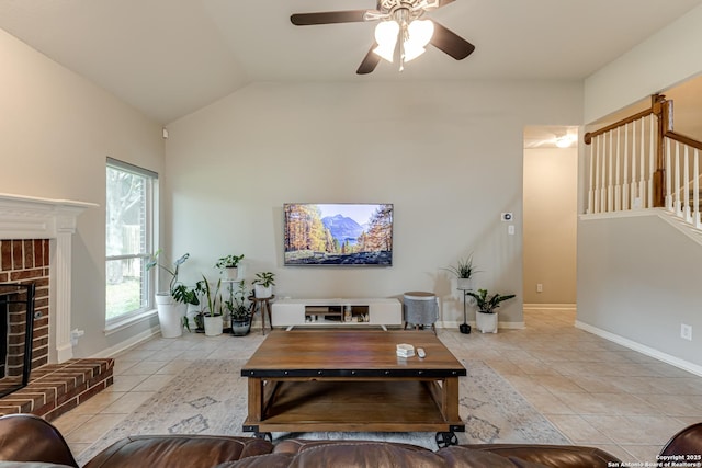 living room with lofted ceiling, a fireplace, ceiling fan, and light tile patterned floors