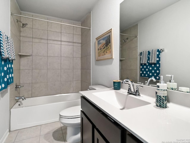 full bathroom with toilet, tile patterned flooring, tiled shower / bath, and vanity