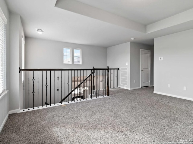 carpeted empty room with a tray ceiling