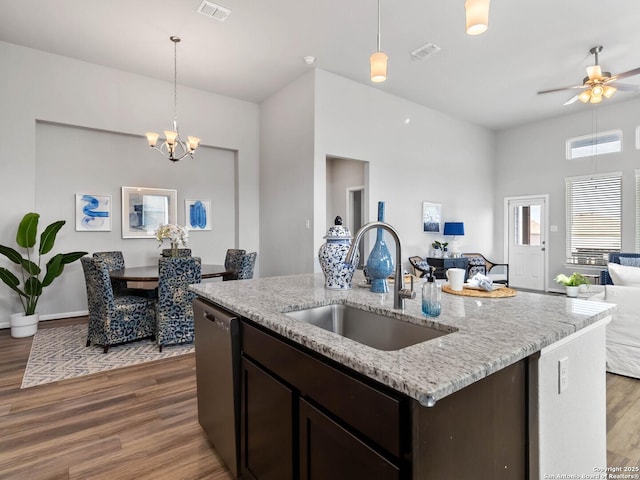 kitchen featuring sink, decorative light fixtures, a kitchen island with sink, and dishwasher