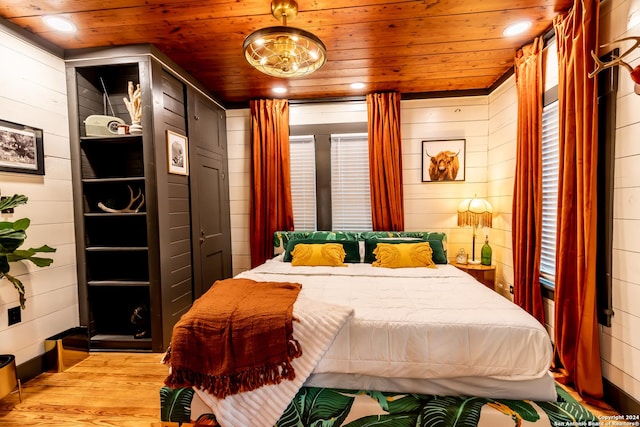 bedroom featuring wood walls, light wood-type flooring, and wood ceiling