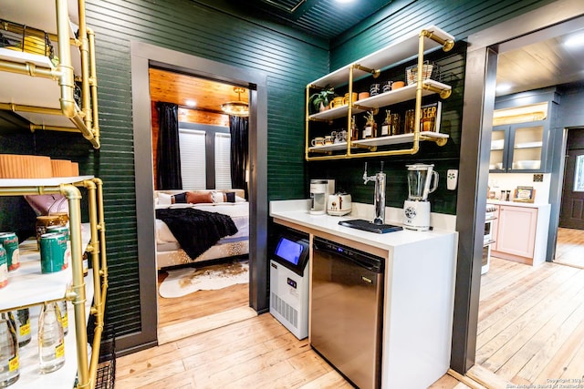 interior space with refrigerator, wood walls, and light hardwood / wood-style flooring