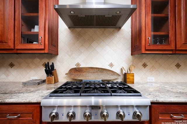 kitchen featuring range hood, stainless steel gas cooktop, tasteful backsplash, and light stone counters