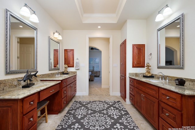 bathroom featuring a tray ceiling, crown molding, and vanity