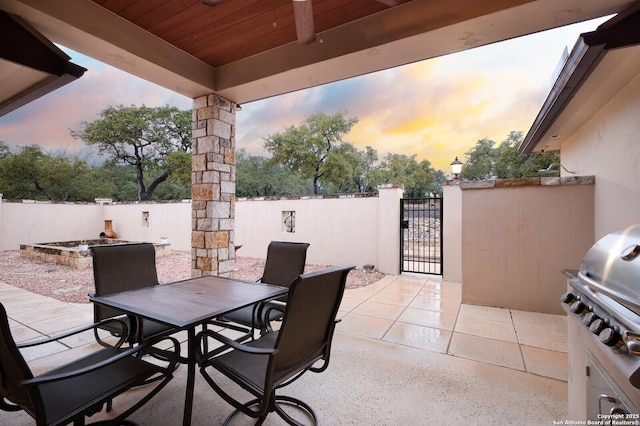 patio terrace at dusk featuring a grill