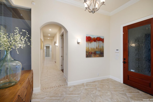 foyer with ornamental molding and a notable chandelier