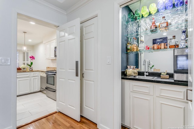 kitchen featuring sink, white cabinetry, ornamental molding, light hardwood / wood-style floors, and stainless steel range with electric stovetop