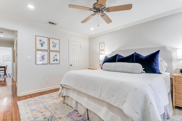 bedroom featuring hardwood / wood-style floors, ceiling fan, and crown molding