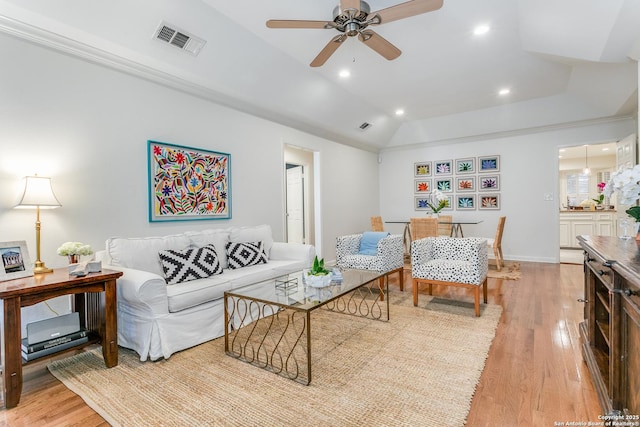 living room featuring lofted ceiling, ornamental molding, ceiling fan, and light hardwood / wood-style floors