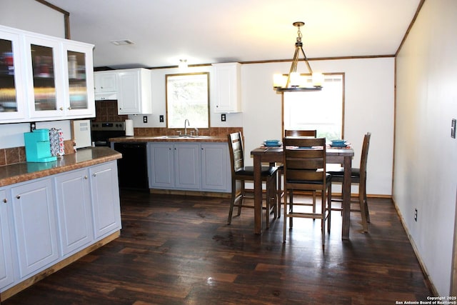 kitchen featuring dishwasher, dark hardwood / wood-style floors, hanging light fixtures, white cabinets, and sink