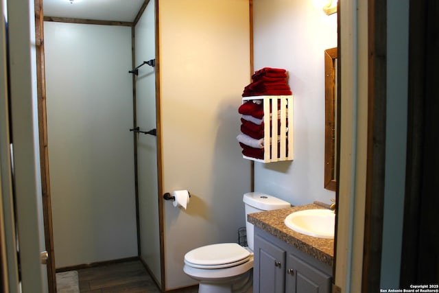 bathroom with hardwood / wood-style floors, vanity, and toilet