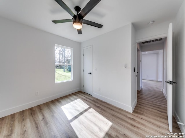 unfurnished bedroom featuring ceiling fan, light hardwood / wood-style floors, and a closet