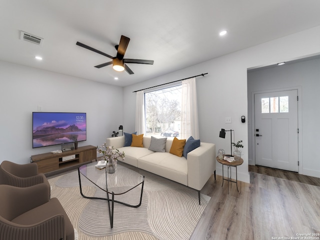 living room with light wood-type flooring and ceiling fan