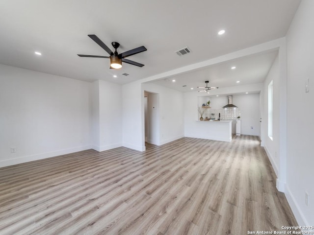 unfurnished living room with ceiling fan and light hardwood / wood-style flooring