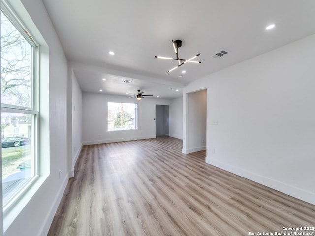 spare room with an inviting chandelier and light wood-type flooring