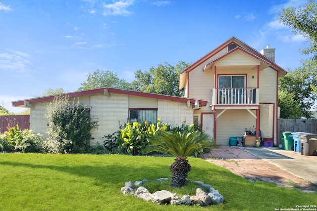 view of front of property featuring a balcony, a patio area, and a front lawn