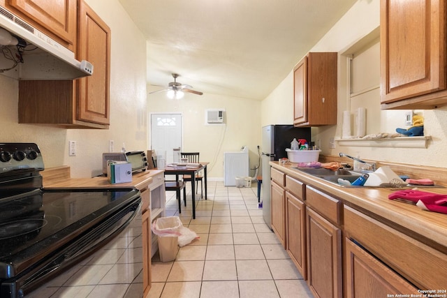 kitchen with vaulted ceiling, black electric range, ceiling fan, light tile patterned floors, and a wall unit AC