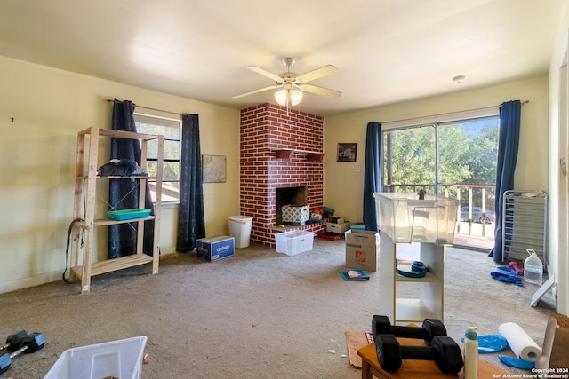 living room featuring a fireplace, ceiling fan, a wealth of natural light, and carpet