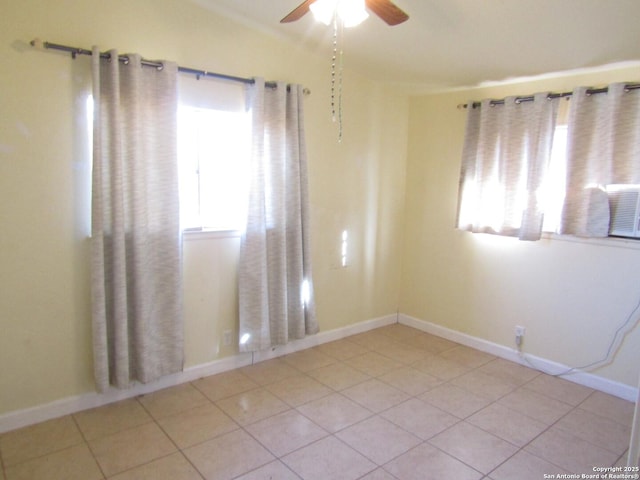 empty room with ceiling fan and light tile patterned floors