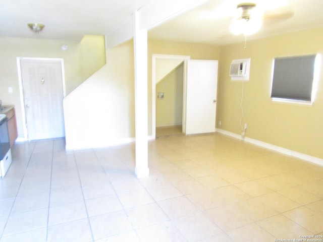 tiled spare room featuring ceiling fan and a wall mounted air conditioner