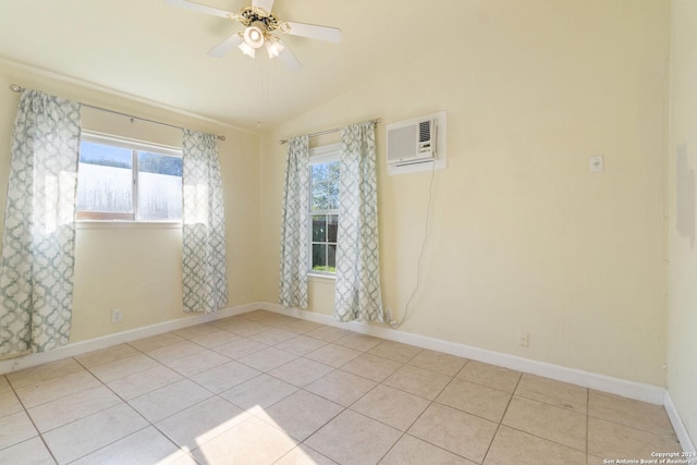 tiled spare room with lofted ceiling, a wall mounted AC, ceiling fan, and a healthy amount of sunlight