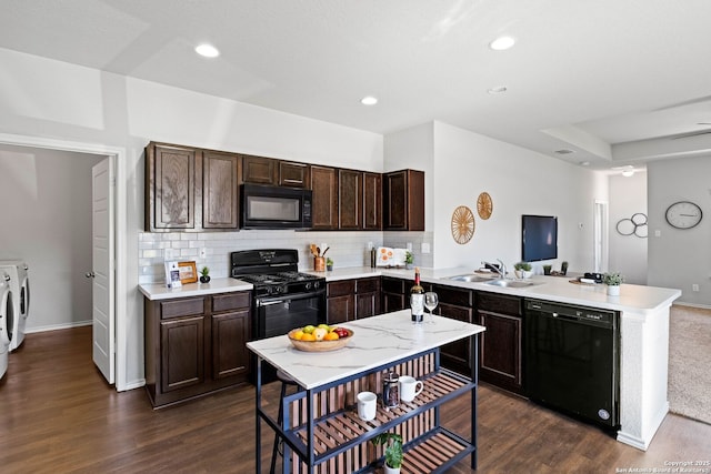 kitchen with sink, separate washer and dryer, kitchen peninsula, decorative backsplash, and black appliances