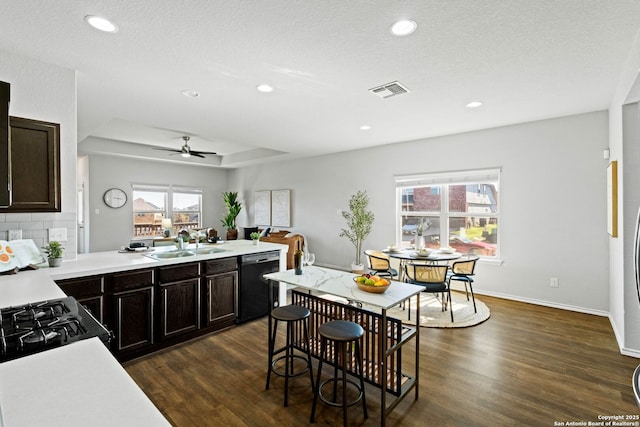 kitchen featuring black appliances, backsplash, dark hardwood / wood-style flooring, ceiling fan, and sink