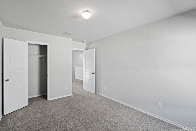 unfurnished bedroom with dark carpet and a closet