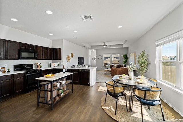 kitchen featuring kitchen peninsula, black appliances, decorative backsplash, ceiling fan, and dark brown cabinetry