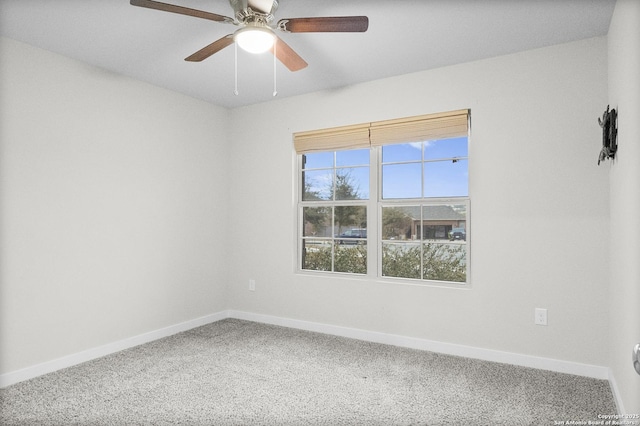 carpeted empty room featuring ceiling fan and baseboards