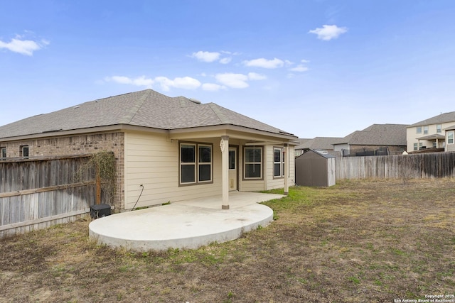 rear view of property with a patio, a lawn, and a storage shed