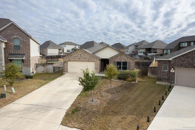 view of front of property with a residential view, concrete driveway, brick siding, and fence