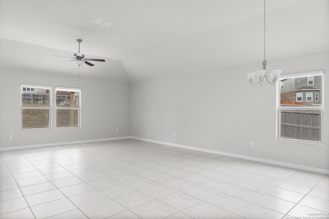 spare room with ceiling fan with notable chandelier, light tile patterned flooring, and vaulted ceiling