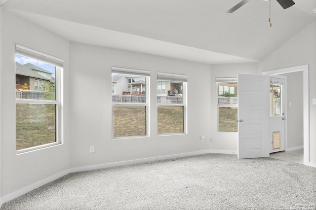 carpeted empty room featuring a ceiling fan, vaulted ceiling, and baseboards