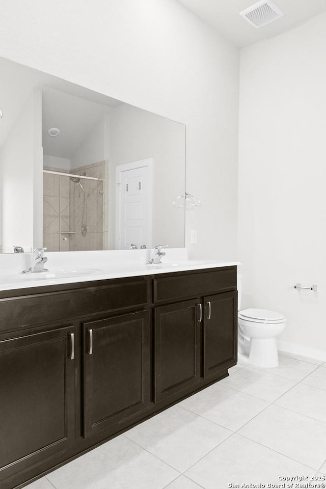 bathroom featuring a shower with door, tile patterned flooring, vanity, and toilet