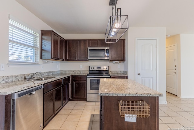 kitchen with appliances with stainless steel finishes, a center island, decorative light fixtures, and dark brown cabinetry