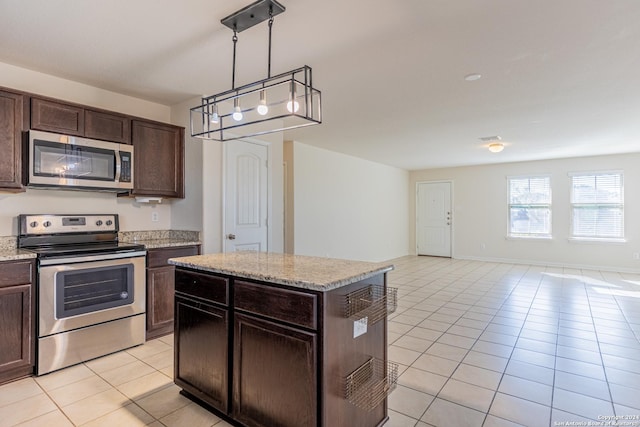 kitchen with a kitchen island, dark brown cabinetry, light tile patterned floors, and appliances with stainless steel finishes