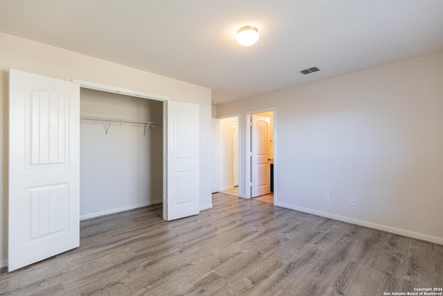 unfurnished bedroom featuring a closet and light hardwood / wood-style flooring