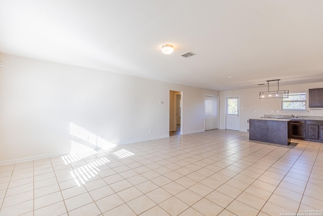 unfurnished living room with light tile patterned floors and sink