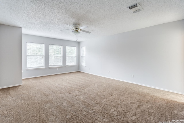 empty room featuring ceiling fan, a textured ceiling, and carpet flooring