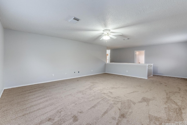 carpeted spare room with ceiling fan and a textured ceiling