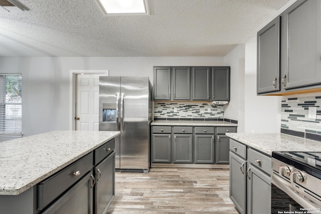 kitchen featuring appliances with stainless steel finishes, tasteful backsplash, and gray cabinets