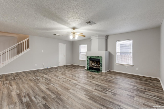 unfurnished living room with a textured ceiling, ceiling fan, and hardwood / wood-style flooring