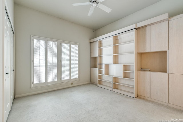 spare room with ceiling fan and light colored carpet