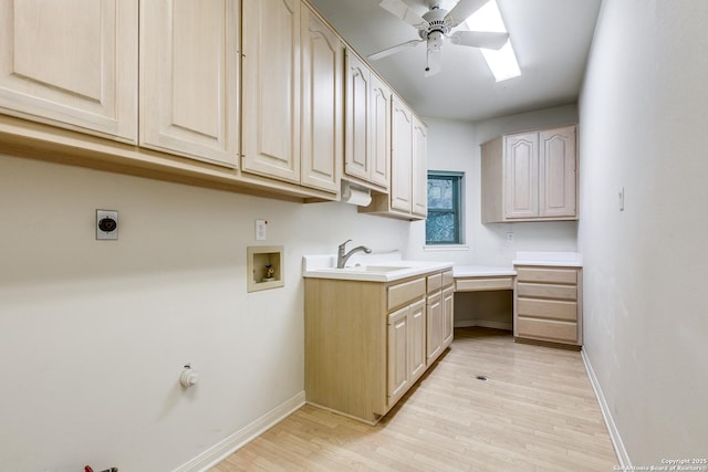 laundry area featuring sink, electric dryer hookup, hookup for a washing machine, cabinets, and light hardwood / wood-style flooring