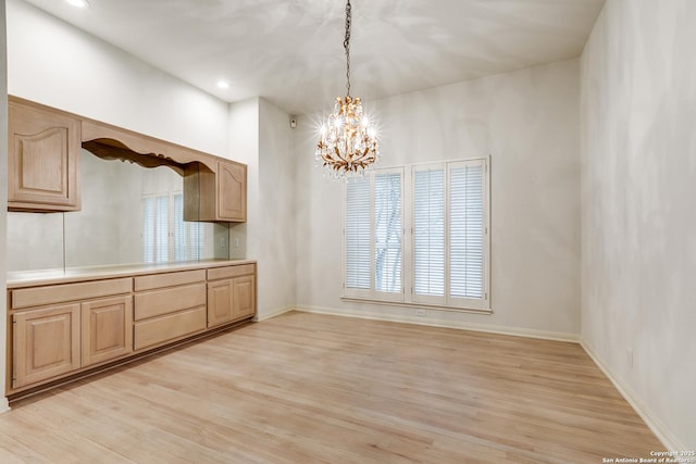 kitchen featuring light hardwood / wood-style floors, decorative light fixtures, a chandelier, and light brown cabinets