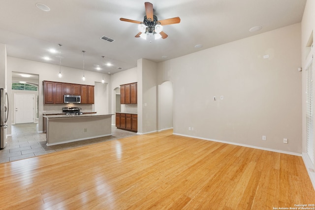 unfurnished living room featuring ceiling fan and light hardwood / wood-style flooring