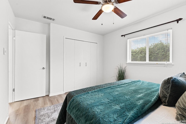 bedroom with ceiling fan, light hardwood / wood-style flooring, and a closet