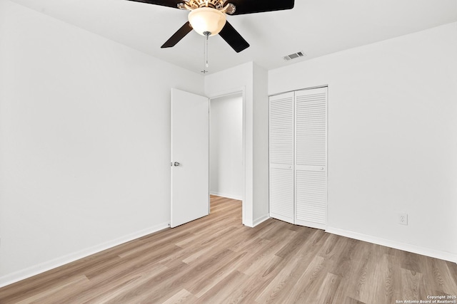 unfurnished bedroom featuring ceiling fan, light hardwood / wood-style floors, and a closet